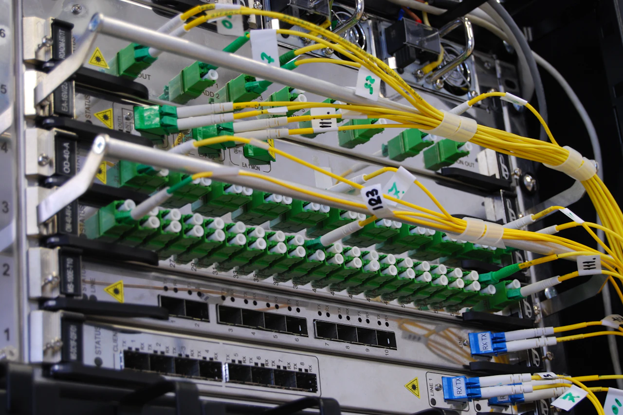 Koneksi serat optik pada perangkat telekomunikasi di rak jaringan
